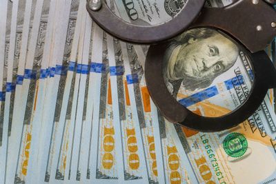 metal-police-handcuffs-and-us-dollar-banknotes-mon-2023-11-27-05-26-08-utc.jpeg